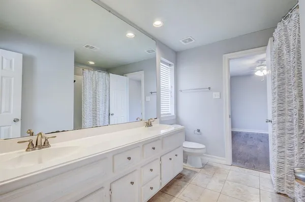 a spacious bathroom with a double vanity sink toilet and a mirror