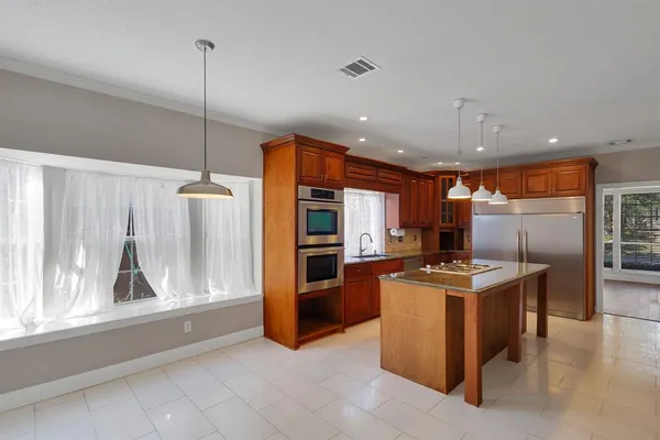 a kitchen with stainless steel appliances granite countertop a stove oven and a refrigerator