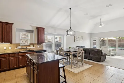 a kitchen with a table chairs and white cabinets