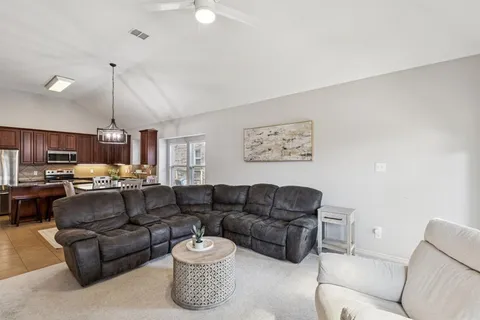 a living room with furniture a ceiling fan and a window