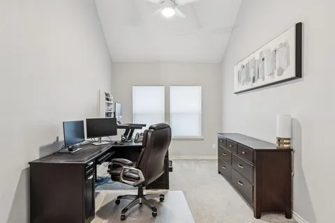 a view of a workspace with furniture and a window