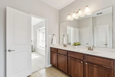 a spacious bathroom with a double vanity sink and a mirror