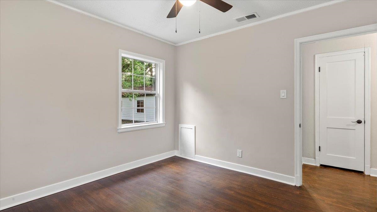 1075 Railton Road Memphis, TN 38111 - Photo 17 of 25 an empty room with wooden floor chandelier fan and windows