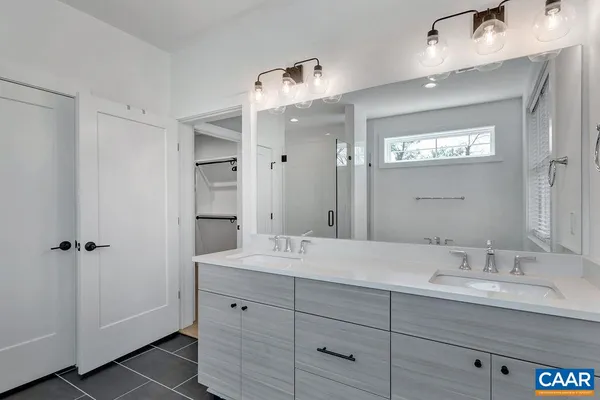 a bathroom with double sink and a mirror