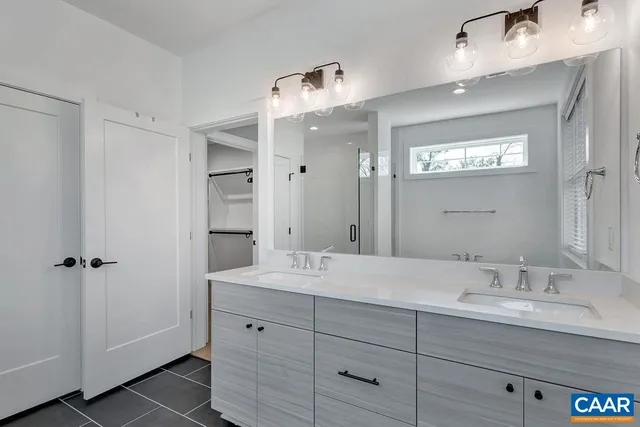 a bathroom with double sink and a mirror