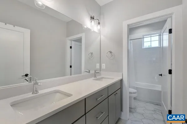 a bathroom with a sink double vanity granite tub and a mirror