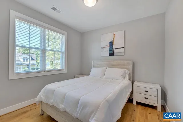 a bedroom with a bed and wooden floor