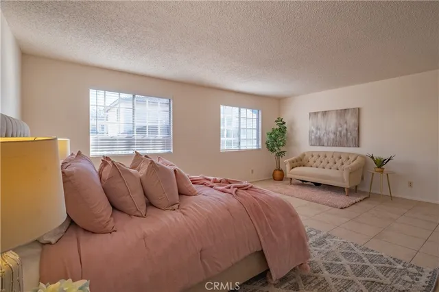 a bedroom with a bed large window and couch