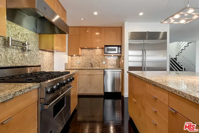 a kitchen with kitchen island a counter space a stove and a refrigerator