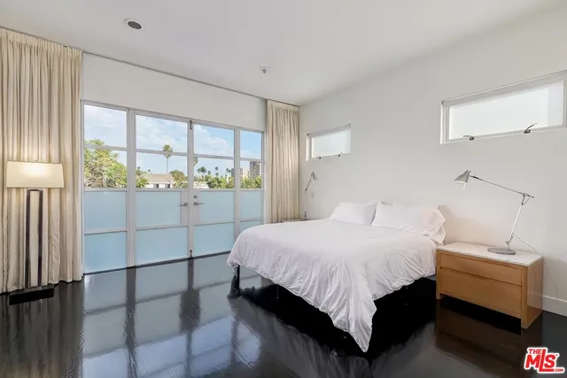 a bedroom with a bed and a large window