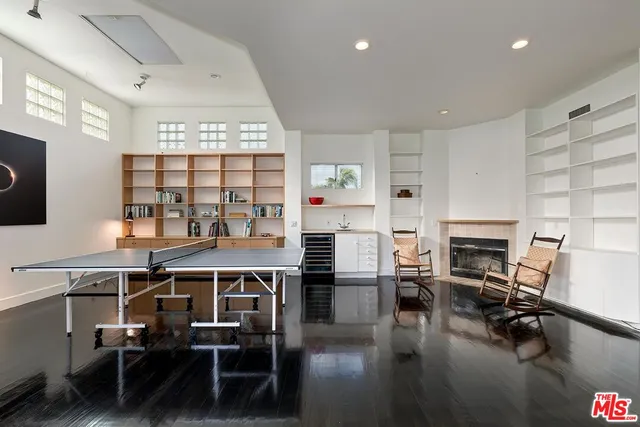 a living room with furniture a flat screen tv and wooden floor