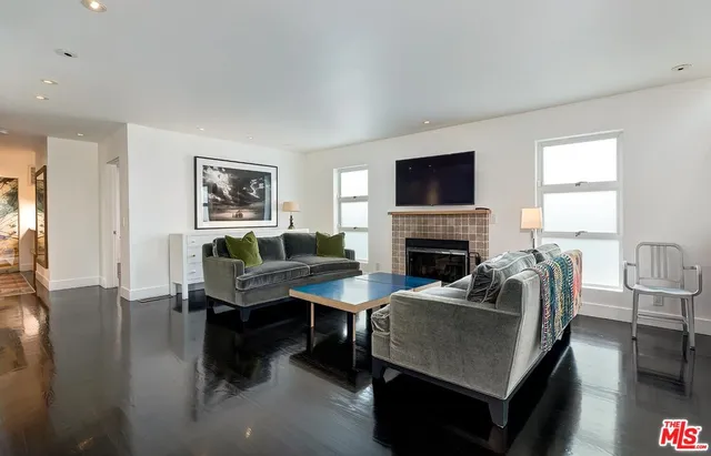 a living room with furniture a flat screen tv and a fireplace