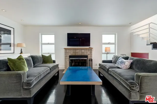 a living room with furniture a flat screen tv and a fireplace