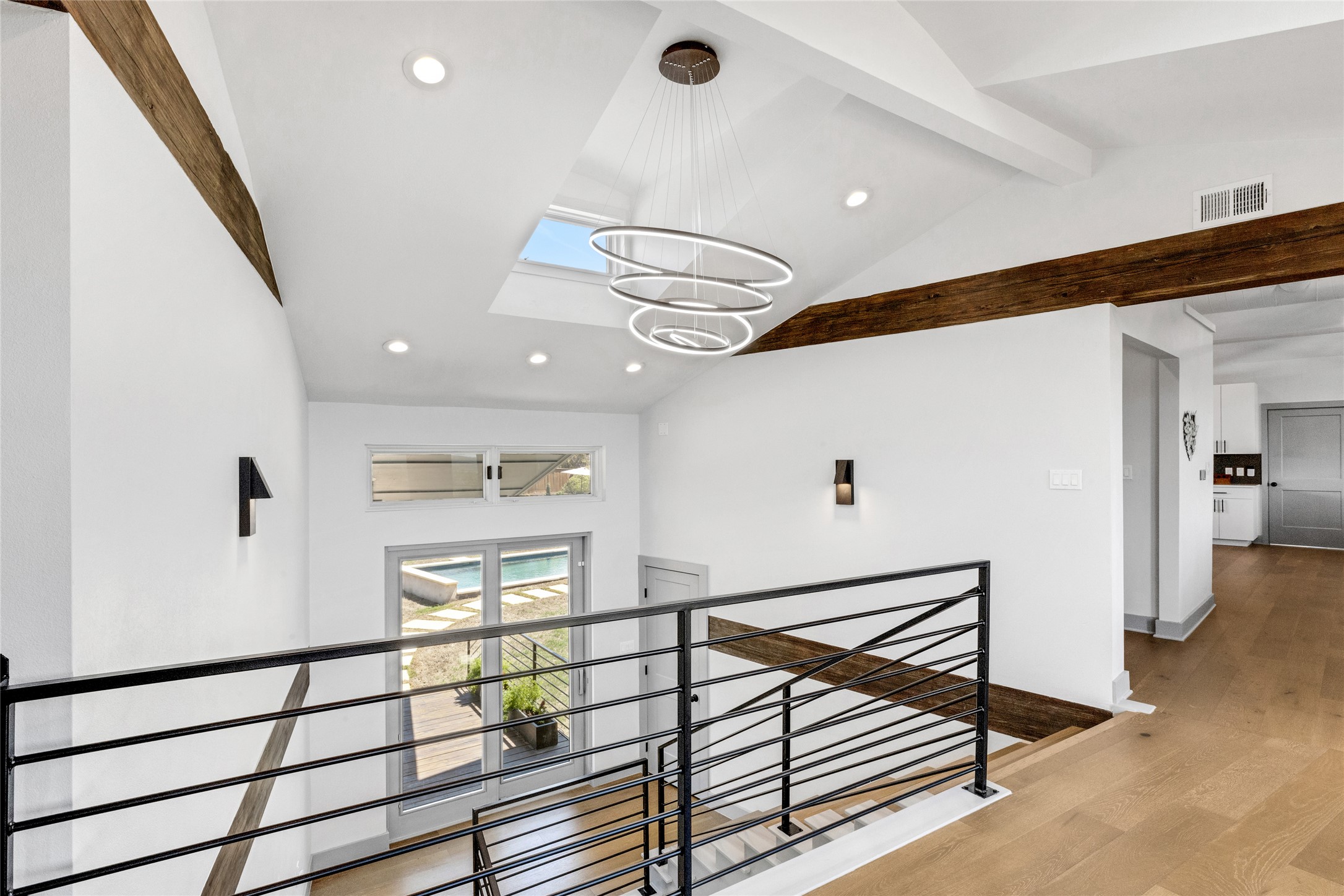 4227 Eck Lane Austin, TX 78734 - Photo 13 of 30 Corridor featuring wood finished floors, recessed lighting, an upstairs landing, a chandelier, and a skylight