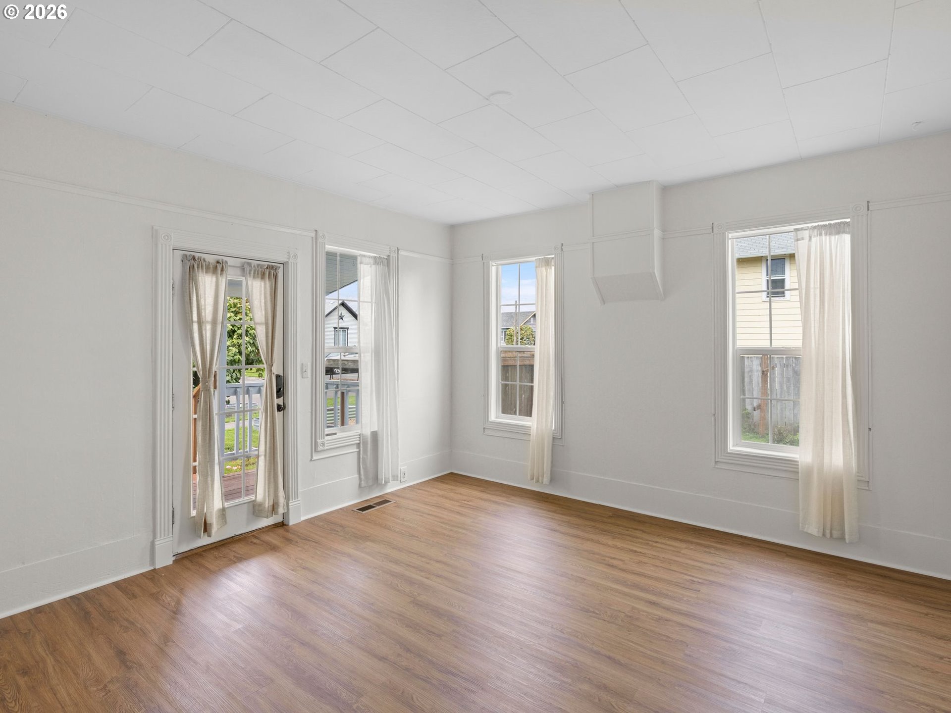 204 South Main Street Newberg, OR 97132 - Photo 4 of 28 a view of an empty room with window and wooden floor