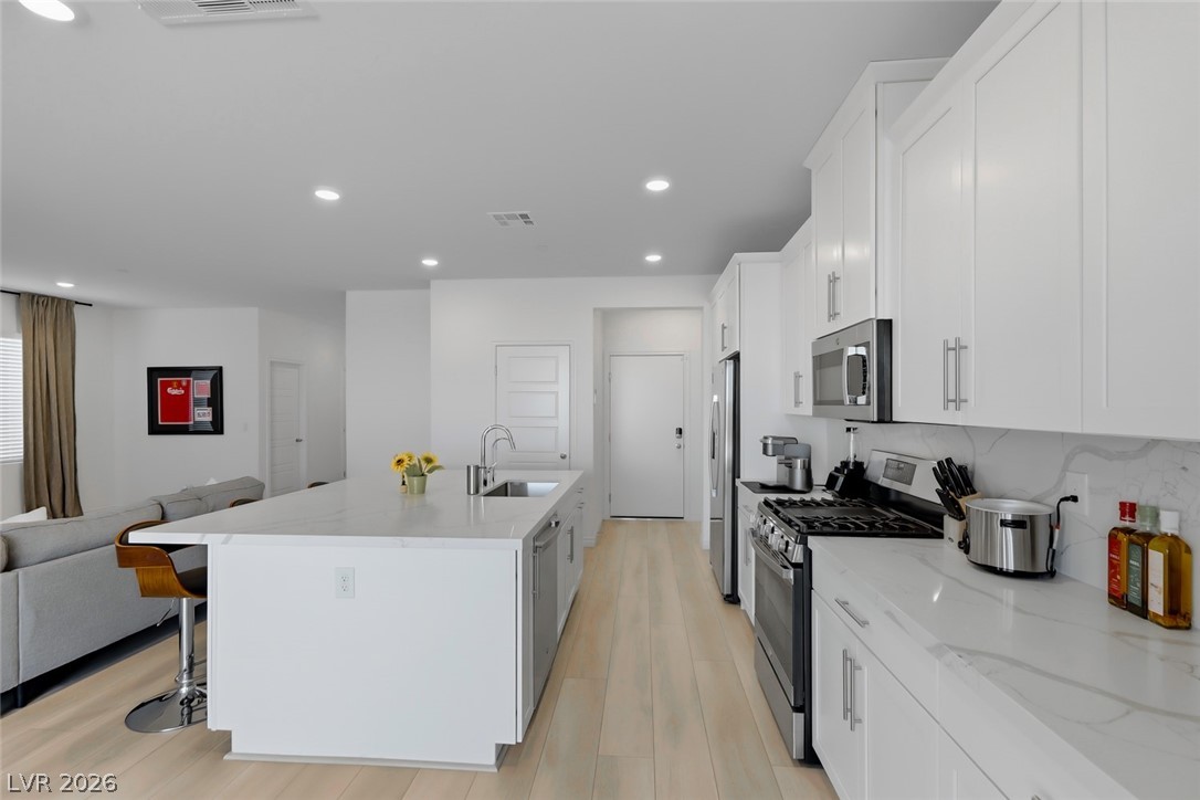 290 Rusty Ridge Lane Henderson, NV 89015 - Photo 9 of 61 Kitchen w/White Shaker Cabinets, Island w/Breakfast Bar, Quartz Countertops, Luxury Vinyl floors, SS Appliances, walk in pantry, dining nook w/abundant cabinet space!