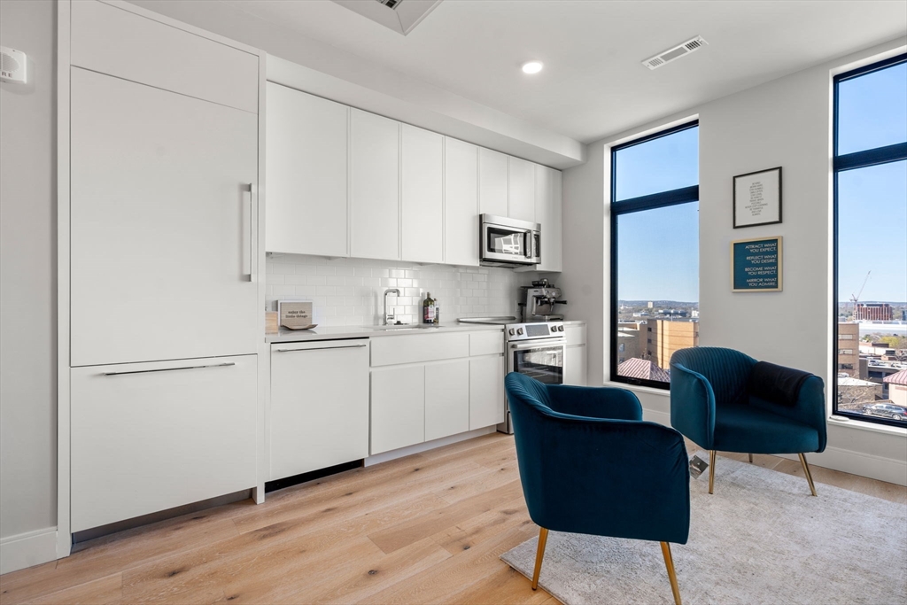 191 Washington Street, Unit 615 Boston, MA 02135 - Photo 2 of 23 a kitchen with a refrigerator and cabinets