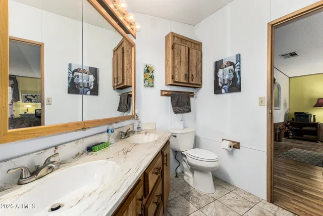 a bathroom with a granite countertop sink mirror and toilet