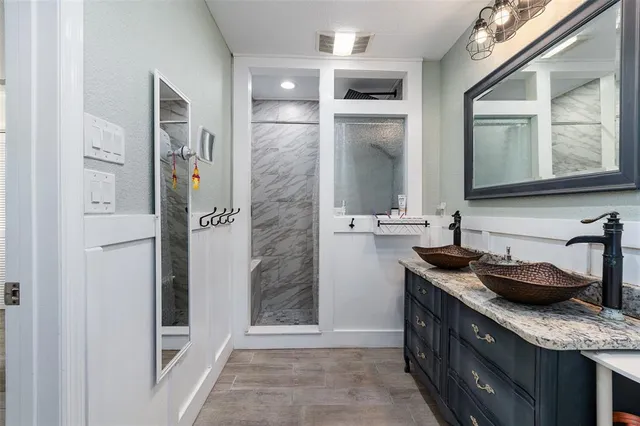 a bathroom with a granite countertop sink and a mirror