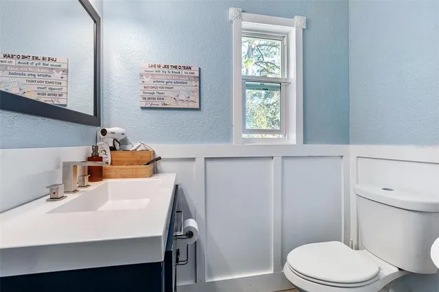 a bathroom with a sink a toilet and a window
