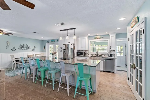 a kitchen with appliances cabinets and chair