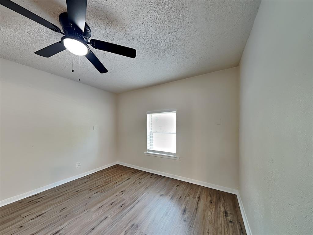 1002 Noble Avenue Carrollton, TX 75006 - Photo 5 of 16 an empty room with wooden floor ceiling fan and window