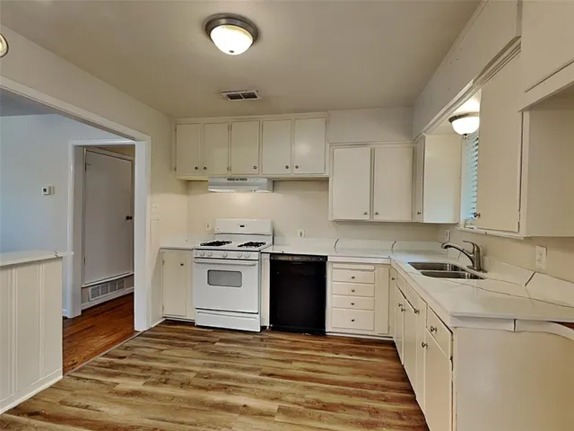 a kitchen with a white stove top oven and white cabinets