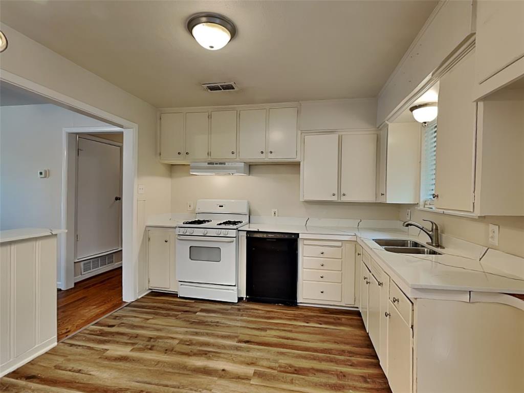1002 Noble Avenue Carrollton, TX 75006 - Photo 7 of 16 a kitchen with a white stove top oven and white cabinets