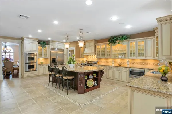 a kitchen with stainless steel appliances granite countertop a refrigerator and a sink