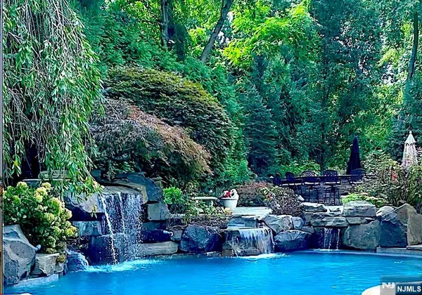 a living room with furniture large windows and wooden floor