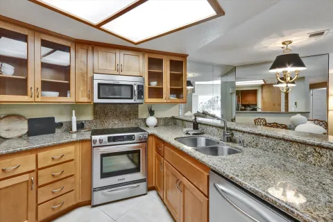 a kitchen with granite countertop a sink stove and microwave