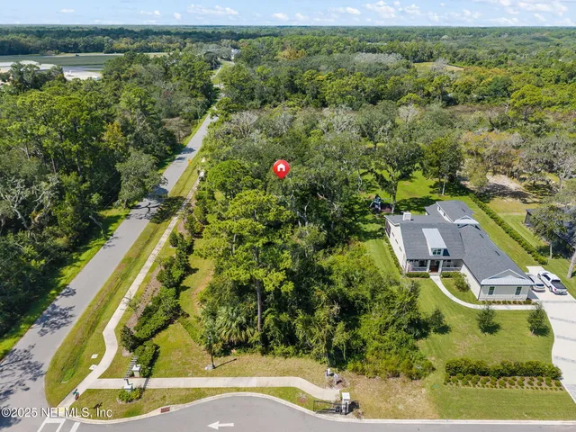 an aerial view of residential houses with outdoor space and trees