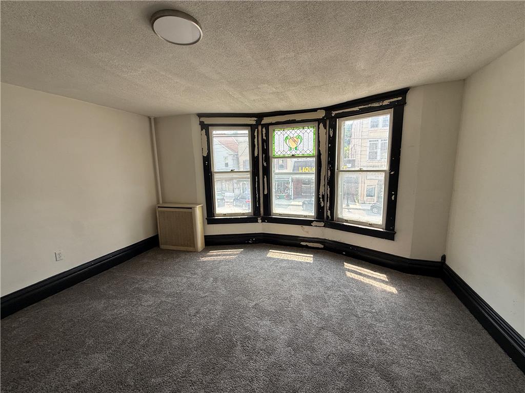 41 West Ridge Street Lansford, PA 18232 - Photo 17 of 40 Well-lit room features soft carpeting and distinctive bay windows, offering ample natural light.