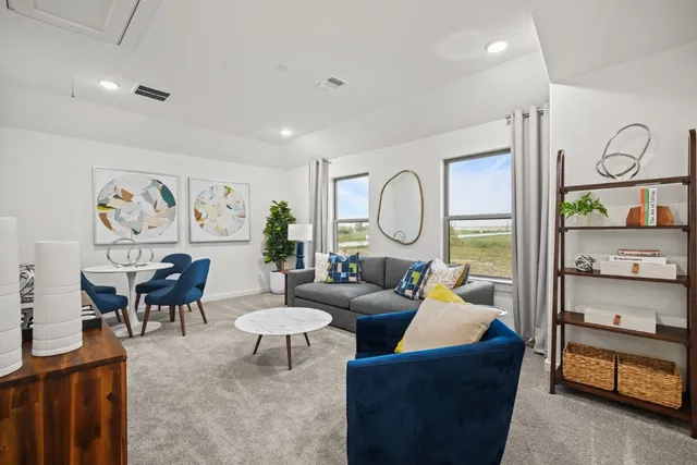 a living room with furniture and a painting on the wall