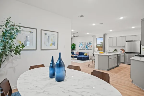 a kitchen with stainless steel appliances granite countertop a refrigerator a stove a sink dishwasher and white cabinets with wooden floor