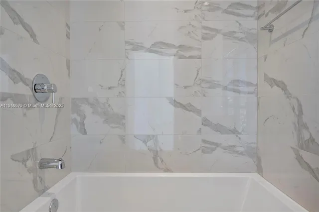 a bathroom with a granite countertop sink a mirror bathtub and shower