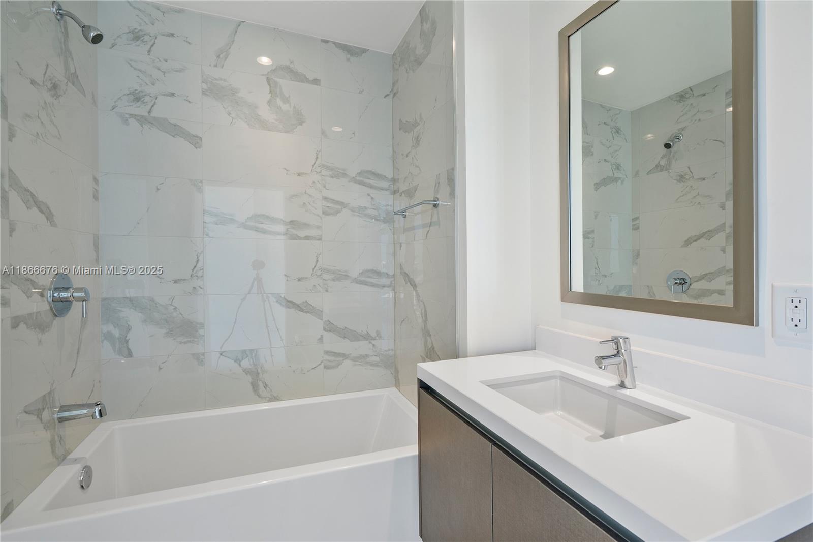 851 Northeast 1st Avenue, Unit 3203 Miami, FL 33132 - Photo 15 of 48 a bathroom with a granite countertop sink a mirror bathtub and shower