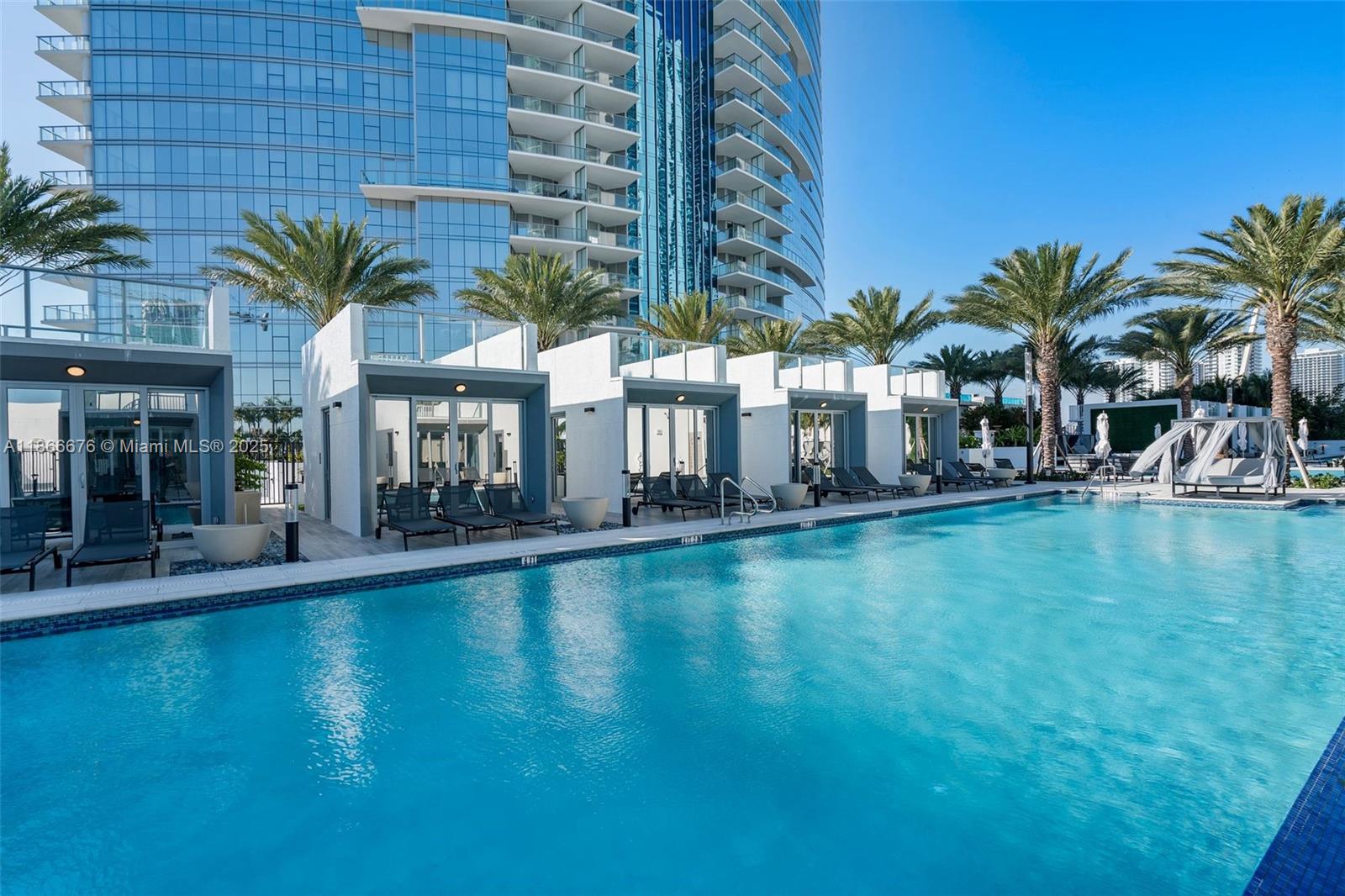851 Northeast 1st Avenue, Unit 3203 Miami, FL 33132 - Photo 20 of 48 a view of a swimming pool with a lawn chairs and palm tree
