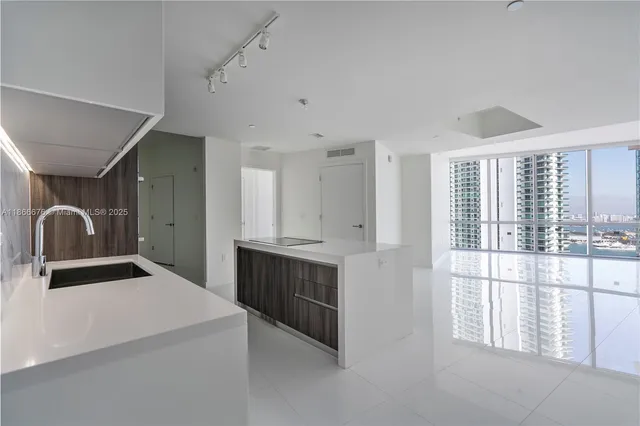 a kitchen with stainless steel appliances a sink and a refrigerator