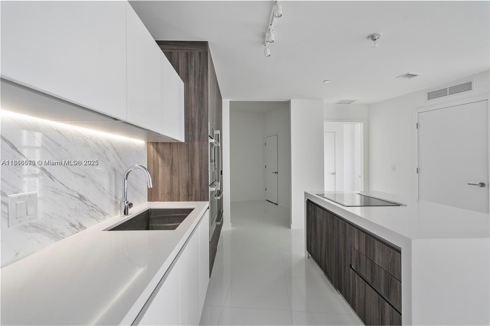 851 Northeast 1st Avenue, Unit 3203 Miami, FL 33132 - Photo 6 of 48 a kitchen with stainless steel appliances a sink and a refrigerator