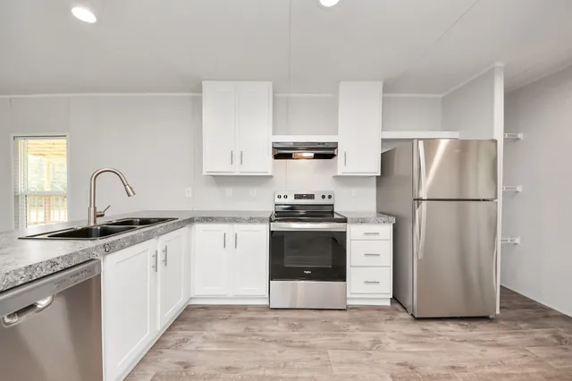 a kitchen with stainless steel appliances granite countertop a refrigerator stove a sink and a granite counter tops