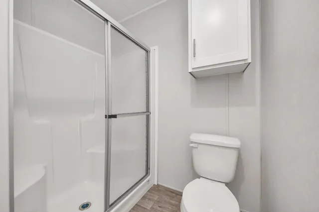 a bathroom with a toilet and a shower