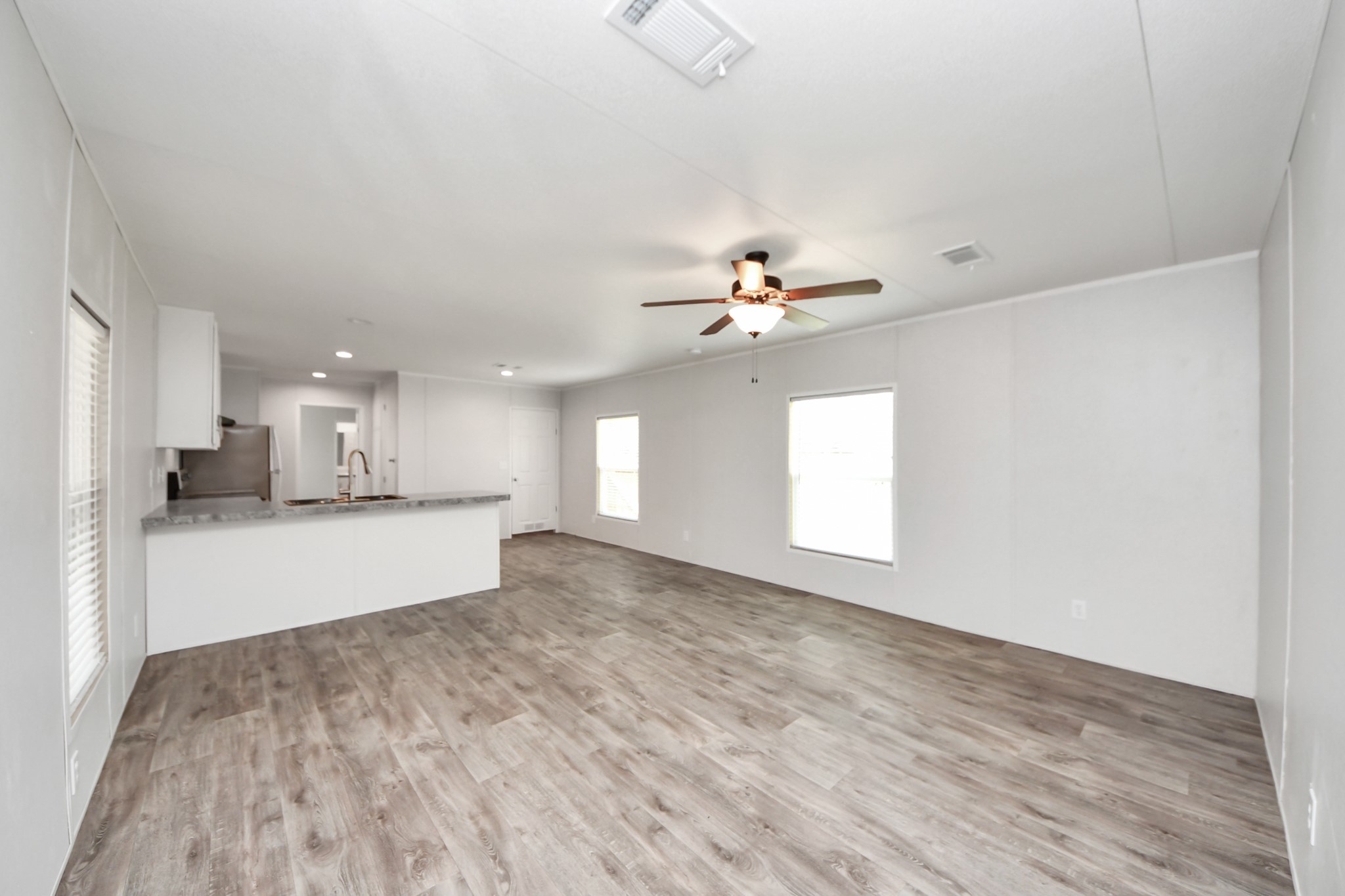1560 Brown Road Willis, TX 77378 - Photo 6 of 28 a view of an empty room and kitchen with wooden floor