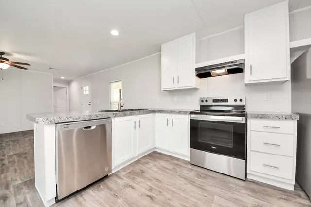 a kitchen with stainless steel appliances white cabinets and a sink