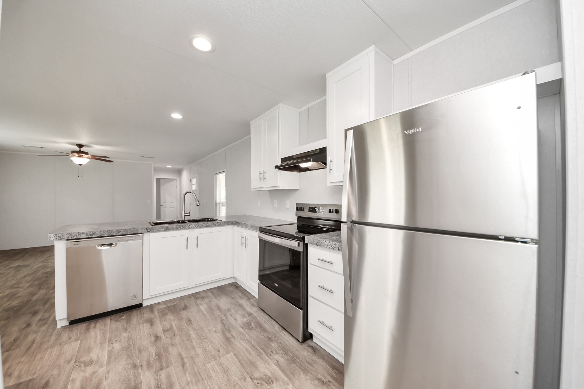 1560 Brown Road Willis, TX 77378 - Photo 10 of 28 a kitchen with stainless steel appliances a refrigerator a sink and white cabinets