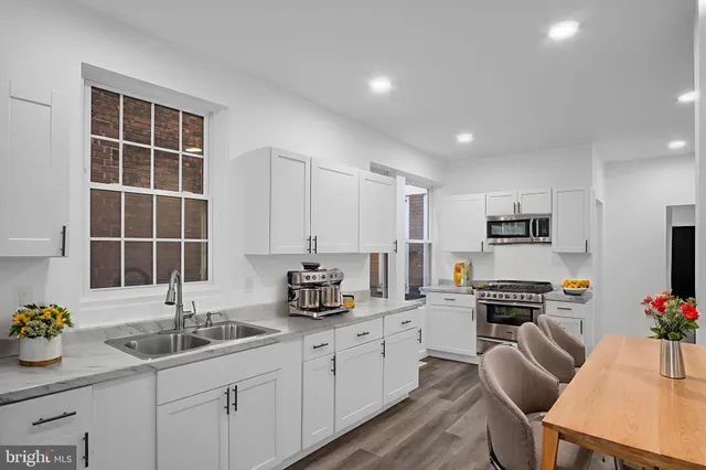 a kitchen with granite countertop a sink stove and refrigerator