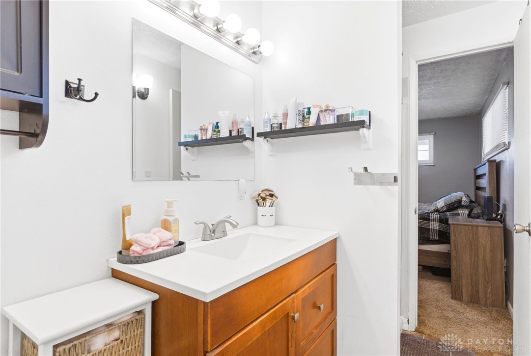 5171 Fishburg Road Dayton, OH 45424 - Photo 27 of 35 This bathroom features a sleek vanity and a well-lit mirror, offering both style and practicality.