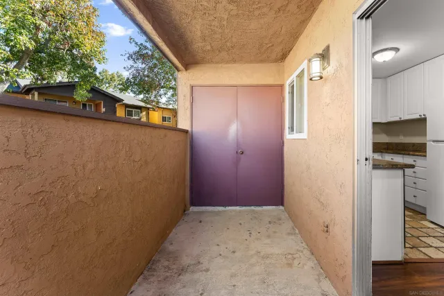 a view of a hallway with wooden floor and a bathroom