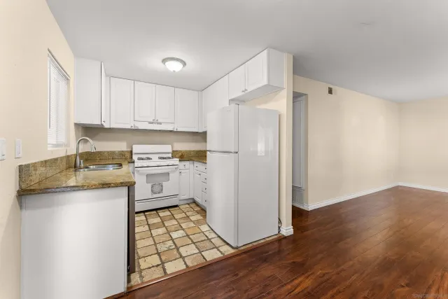 a kitchen with white cabinets and white appliances