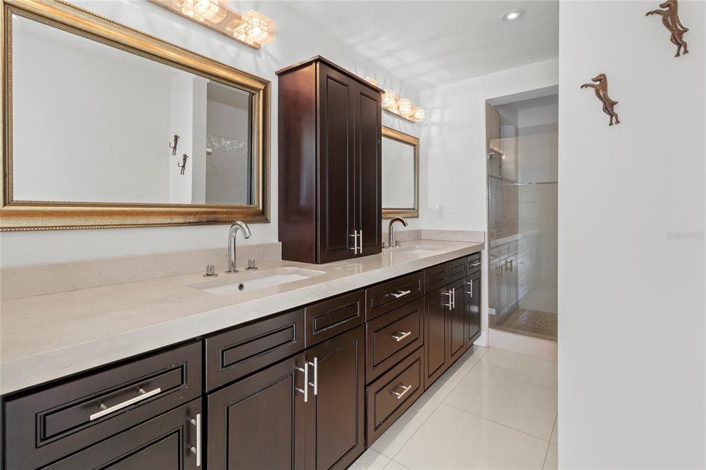 400 Golden Gate Point, Unit 11 Sarasota, FL 34236 - Photo 17 of 42 a bathroom with a double vanity sink and mirror